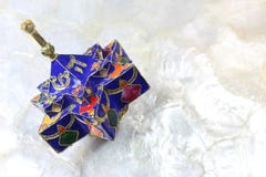 Enameled blue star shaped Hanukkah dreidel on a soft white background royalty free stock photo Enameled blue star shaped Hanukkah dreidel on a soft white background royalty free stock photo