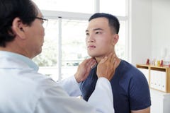 Endocrynologist проверяя тиреоид пациента стоковая фотография rf Endocrynologist проверяя тиреоид пациента стоковая фотография rf