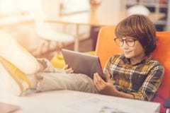 Enfant avec plaisir heureux à l'aide d'un comprimé images stock Enfant avec plaisir heureux à l'aide d'un comprimé images stock