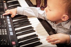Enfant d'enfant de garçon jouant sur le synthétiseur numérique de piano de clavier photos libres de droits Enfant d'enfant de garçon jouant sur le synthétiseur numérique de piano de clavier photos libres de droits