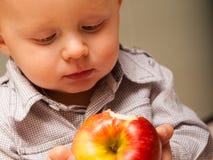 Enfant d'enfant de petit garçon mangeant du fruit de pomme à la maison photos libres de droits Enfant d'enfant de petit garçon mangeant du fruit de pomme à la maison photos libres de droits