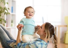 Enfant et maman de sourire ayant un passe-temps d'amusement sur le plancher chez la pièce des enfants à la maison photos stock Enfant et maman de sourire ayant un passe-temps d'amusement sur le plancher chez la pièce des enfants à la maison photos stock