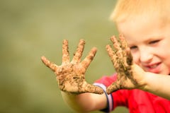 Enfant jouant les mains boueuses sales d'apparence extérieure photos stock Enfant jouant les mains boueuses sales d'apparence extérieure photos stock