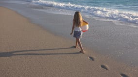 Enfant jouant sur la plage au coucher du soleil, enfant heureux marchant dans la fille de vagues de mer sur le bord de la mer image libre de droits Enfant jouant sur la plage au coucher du soleil, enfant heureux marchant dans la fille de vagues de mer sur le bord de la mer image libre de droits