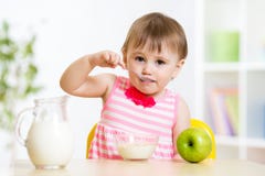 Enfant mangeant de la nourriture elle-même avec la cuillère images libres de droits Enfant mangeant de la nourriture elle-même avec la cuillère images libres de droits