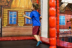 Enfant sur le trempoline au terrain de jeu Images libres de droits Enfant sur le trempoline au terrain de jeu Images libres de droits