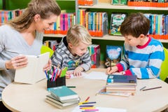Enfantez le livre de lecture de la bibliothèque à son fils photographie stock Enfantez le livre de lecture de la bibliothèque à son fils photographie stock