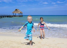 Enfants courant sur la plage ensemble photographie stock libre de droits Enfants courant sur la plage ensemble photographie stock libre de droits