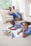 Enfants de mêmes parents heureux sur le dessin de plancher Photo stock Enfants de mêmes parents heureux sur le dessin de plancher Photo stock
