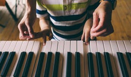 Enfants et mains des femmes sur les clés de piano photos stock Enfants et mains des femmes sur les clés de piano photos stock