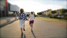 Enfants heureux courant tenir ensemble des mains sur la route Les rayons du soleil brillent dans leurs visages banque de vidéos Enfants heureux courant tenir ensemble des mains sur la route Les rayons du soleil brillent dans leurs visages banque de vidéos