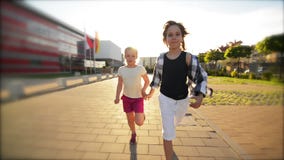 Enfants heureux courant tenir ensemble des mains sur la route Les rayons du soleil brillent dans leurs visages clips vidéos Enfants heureux courant tenir ensemble des mains sur la route Les rayons du soleil brillent dans leurs visages clips vidéos