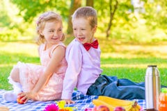Enfants heureux dans une belle robe sur un pique-nique photographie stock libre de droits Enfants heureux dans une belle robe sur un pique-nique photographie stock libre de droits