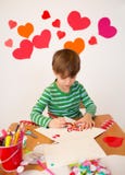 Enfants occupés dans des arts de Saint-Valentin avec des coeurs photos libres de droits Enfants occupés dans des arts de Saint-Valentin avec des coeurs photos libres de droits
