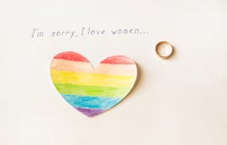 Engagement ring on a white background and the inscription I love women, heart in the form of a LGBT flag, lesbian stock photo Engagement ring on a white background and the inscription I love women, heart in the form of a LGBT flag, lesbian stock photo