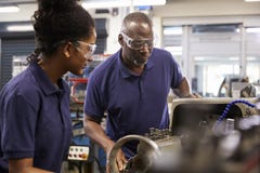 Engineer Showing Female Teenage Apprentice How To Use Lathe stock photos Engineer Showing Female Teenage Apprentice How To Use Lathe stock photos