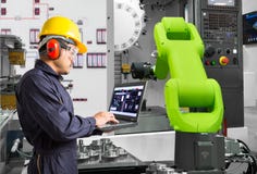 Engineer using laptop computer control automatic robotic hand machine tool with CNC machine in automotive industry, Industry 4.0 royalty free stock photo Engineer using laptop computer control automatic robotic hand machine tool with CNC machine in automotive industry, Industry 4.0 royalty free stock photo