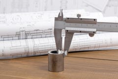 Measurement of the metal part with a caliper on the background of engineering drawings Royalty Free Stock Image Measurement of the metal part with a caliper on the background of engineering drawings Royalty Free Stock Image
