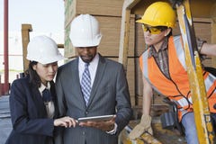Engineers and female industrial worker looking at tablet PC stock photography Engineers and female industrial worker looking at tablet PC stock photography