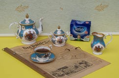 English tea set, a package of original English Tetley`s teabags and reading glasses on an old German daily newspaper Der Patriot stock image English tea set, a package of original English Tetley`s teabags and reading glasses on an old German daily newspaper Der Patriot stock image