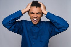 Enraged African American teenager grabs for head. Royalty Free Stock Photography Enraged African American teenager grabs for head. Royalty Free Stock Photography