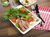 Ensalada con el arugula, carne de vaca frita, tomates, higos fotos de archivo Ensalada con el arugula, carne de vaca frita, tomates, higos fotos de archivo