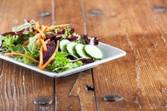 Ensalada fresca colorida del arugula en la tabla de madera rústica imágenes de archivo libres de regalías Ensalada fresca colorida del arugula en la tabla de madera rústica imágenes de archivo libres de regalías