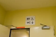 An entrance to the male, female and disabled toilet. wc symbol on yellow wall royalty free stock image An entrance to the male, female and disabled toilet. wc symbol on yellow wall royalty free stock image