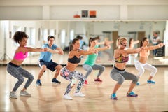Entraîneur féminin avec les jeunes faisant des exercices photos stock Entraîneur féminin avec les jeunes faisant des exercices photos stock