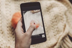 Entregue guardar o telefone e tomar a foto da abóbora e da folha em morno Fotografia de Stock