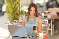 Entreprenör som arbetar med en telefon och en bärbar dator i en coffee shop arkivfoton Entreprenör som arbetar med en telefon och en bärbar dator i en coffee shop arkivfoton