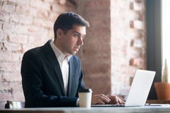 Entsetzter Geschäftsmann, der Laptopschirm betrachtet stockbild Entsetzter Geschäftsmann, der Laptopschirm betrachtet stockbild