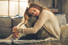 Entspannte junge Frau, die in der Dachbodenwohnung sitzt stockfoto Entspannte junge Frau, die in der Dachbodenwohnung sitzt stockfoto