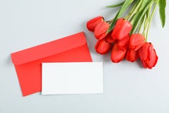 Envelopes with space for text and beautiful red tulips on light grey background royalty free stock photography Envelopes with space for text and beautiful red tulips on light grey background royalty free stock photography