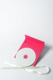 Enveloppe rouge avec le ruban jaune sous forme d'arc pour le CD, position verticale Enveloppe carrée images libres de droits Enveloppe rouge avec le ruban jaune sous forme d'arc pour le CD, position verticale Enveloppe carrée images libres de droits