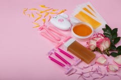 Epilator disponibel rakkniv, vax, vaxremsor med rosor på en rosa bakgrund, utrymme för text arkivbild Epilator disponibel rakkniv, vax, vaxremsor med rosor på en rosa bakgrund, utrymme för text arkivbild