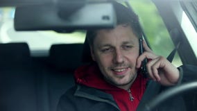 Equipaggi condurre l'automobile che seleziona il telefono e che ondeggia ai passanti Equipaggi condurre l'automobile che seleziona il telefono e che ondeggia ai passanti