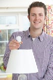 Equipaggi mettere la lampadina di energia bassa LED nella lampada a casa immagine stock libera da diritti Equipaggi mettere la lampadina di energia bassa LED nella lampada a casa immagine stock libera da diritti