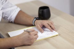 Equipaggia le mani sull'attrezzatura bianca scrive con la penna del rullo sulla carta sulla tavola di legno un certo Latino, o i fotografia stock libera da diritti Equipaggia le mani sull'attrezzatura bianca scrive con la penna del rullo sulla carta sulla tavola di legno un certo Latino, o i fotografia stock libera da diritti