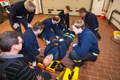 Equipe alemão do sapador-bombeiro em um exercício com ferido em uma maca fotografia de stock Equipe alemão do sapador-bombeiro em um exercício com ferido em uma maca fotografia de stock