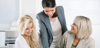 Equipe bem sucedida da mulher de negócios bem-educado que senta-se na mesa w imagem de stock Equipe bem sucedida da mulher de negócios bem-educado que senta-se na mesa w imagem de stock