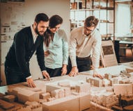 Equipe segura dos coordenadores que trabalham junto em um estúdio do arquiteto imagens de stock Equipe segura dos coordenadores que trabalham junto em um estúdio do arquiteto imagens de stock