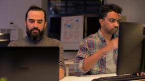 Equipo creativo con el ordenador que trabaja tarde en la oficina almacen de metraje de vídeo Equipo creativo con el ordenador que trabaja tarde en la oficina almacen de metraje de vídeo