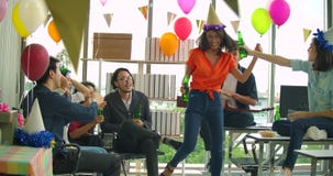 Equipo de baile y de divertirse de celebrar con la tostada y de tintinear de la gente joven aumentando los vidrios en su oficina almacen de metraje de vídeo Equipo de baile y de divertirse de celebrar con la tostada y de tintinear de la gente joven aumentando los vidrios en su oficina almacen de metraje de vídeo