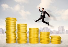 Erfolgreicher Geschäftsmann, der oben auf Goldmünzgeld springt Stockbilder Erfolgreicher Geschäftsmann, der oben auf Goldmünzgeld springt Stockbilder