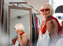 Erfreute ältere Frau, die ihren Kauf nah an Kasten hält lizenzfreie stockfotos Erfreute ältere Frau, die ihren Kauf nah an Kasten hält lizenzfreie stockfotos