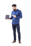 Ernster erfolgreicher Geschäftsmann, der unten Tablet-Computer-leerem Bildschirm darstellt und betrachtet Lizenzfreies Stockbild Ernster erfolgreicher Geschäftsmann, der unten Tablet-Computer-leerem Bildschirm darstellt und betrachtet Lizenzfreies Stockbild
