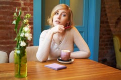 Ernstig nadenkend meisje die de camera bekijken Een jonge vrouw het drinken koffie in een koffie tegen een bakstenen muur en een stock afbeeldingen Ernstig nadenkend meisje die de camera bekijken Een jonge vrouw het drinken koffie in een koffie tegen een bakstenen muur en een stock afbeeldingen