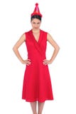 Ernstig schitterend brunette in rode kleding die partijhoed dragen stock foto Ernstig schitterend brunette in rode kleding die partijhoed dragen stock foto