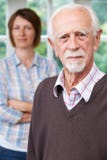 Ernstige Hogere Mens met Volwassen Dochter thuis stock foto Ernstige Hogere Mens met Volwassen Dochter thuis stock foto
